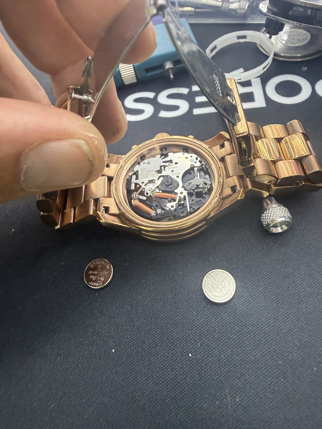 Open watch mechanism held beside tools