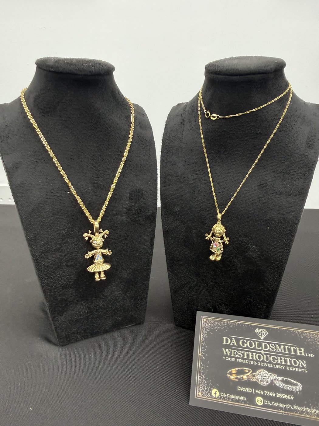 Gold necklaces displayed on black stands