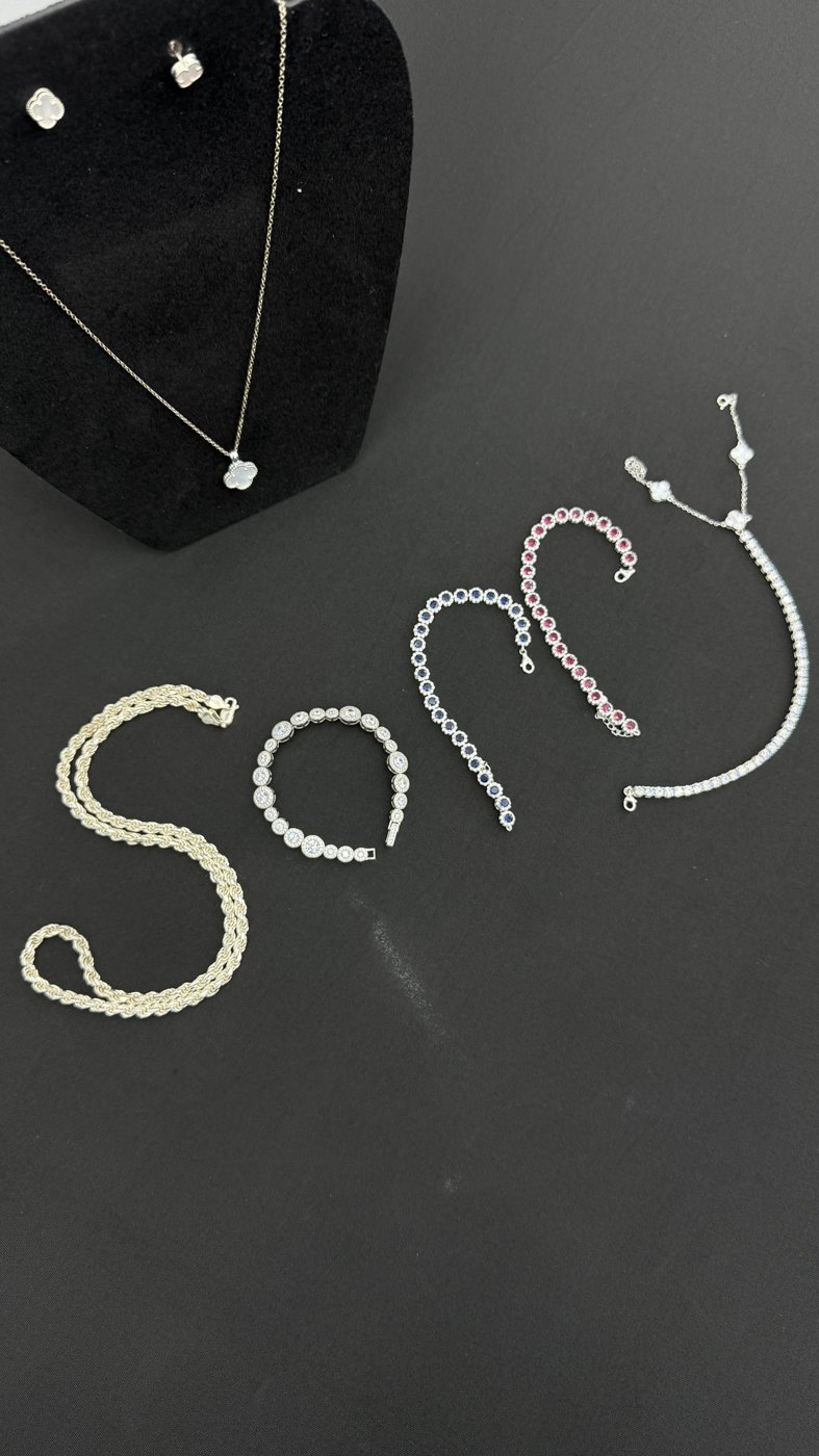 Chains and pendant jewellery arranged on a dark surface