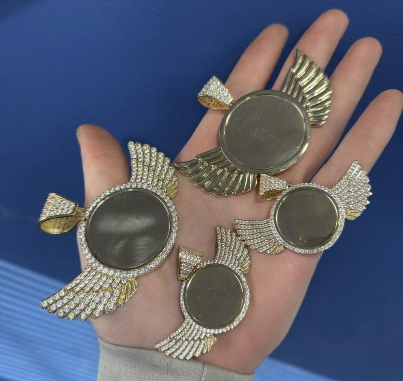 Angel-shaped pendants held in a palm